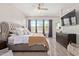 Serene main bedroom with a tufted headboard, ceiling fan, and large windows at 11807 W Parkway Ln, Avondale, AZ 85323