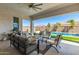 Inviting covered patio with ceiling fan, comfortable seating, and view of the sparkling pool at 11807 W Parkway Ln, Avondale, AZ 85323