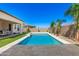 Refreshing backyard pool with travertine decking, lush landscaping, and ample space for relaxation at 11807 W Parkway Ln, Avondale, AZ 85323