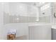 Elegant bathroom shower featuring white subway tile with grey accent stripe and glass door at 11807 W Parkway Ln, Avondale, AZ 85323