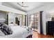 Bright bedroom featuring a comfortable queen bed, mirrored closet doors, wood floors and balcony access at 1211 N Miller Rd # 258, Scottsdale, AZ 85257