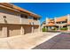 Exterior elevation showcasing multiple garages with red tile roofs, and stucco walls, and common parking at 1211 N Miller Rd # 258, Scottsdale, AZ 85257