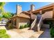 Two-story condo with a red tile roof and private entrance, accented by manicured landscaping and clear blue skies at 1211 N Miller Rd # 258, Scottsdale, AZ 85257