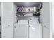 Well-organized laundry closet featuring a white washer and dryer set with shelving for storage at 1211 N Miller Rd # 258, Scottsdale, AZ 85257