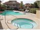 Community pool area with jacuzzi, lounge chairs and umbrellas, great for soaking up the sun and relaxing at 1211 N Miller Rd # 258, Scottsdale, AZ 85257