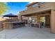 Covered patio with ceiling fans, stone bar, and outdoor dining area perfect for entertaining at 122 W Raven Dr, Chandler, AZ 85286