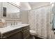 Bathroom featuring a vanity with marble countertop, framed mirror, and shower with patterned curtain at 122 W Raven Dr, Chandler, AZ 85286