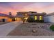 Beautiful two-story home featuring a three-car garage, desert landscaping, and a tile roof set against a colorful sunset sky at 122 W Raven Dr, Chandler, AZ 85286