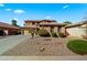 Beautiful two-story home featuring a three-car garage, desert landscaping, and a tile roof on a sunny day at 122 W Raven Dr, Chandler, AZ 85286