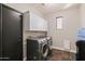 Efficient laundry room features a washer and dryer, storage cabinets, and an exterior entrance at 122 W Raven Dr, Chandler, AZ 85286