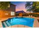 Backyard view of a sparkling pool, landscaped yard, and covered patio for outdoor enjoyment at 122 W Raven Dr, Chandler, AZ 85286