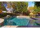 Sparkling pool with stone accents, surrounded by lush landscaping and lounge chairs, perfect for relaxation at 122 W Raven Dr, Chandler, AZ 85286