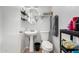 Functional bathroom with pedestal sink, toilet, and open shelving for storage at 12608 W Lower Buckeye Rd, Avondale, AZ 85323