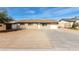 Single-story home features a spacious front yard with a long driveway and an attached single car garage at 12608 W Lower Buckeye Rd, Avondale, AZ 85323