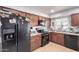 Functional kitchen featuring wooden cabinets, black appliances, and a cozy window view at 12608 W Lower Buckeye Rd, Avondale, AZ 85323