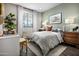 Cozy bedroom with neutral tones, a patterned quilt, and sunlight streaming through the window at 12642 W Parkway Ln, Avondale, AZ 85323