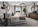 Serene main bedroom featuring a king bed, stylish decor, natural light, and mountain views at 12651 W Parkway Ln, Avondale, AZ 85323