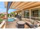 Outdoor patio with built in seating and fire table that overlooks a lovely pool and beautiful backyard at 1275 E Verde Blvd, Queen Creek, AZ 85140