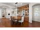 Elegant dining room featuring a modern chandelier and a built-in dry bar with glass shelving at 1275 E Verde Blvd, Queen Creek, AZ 85140