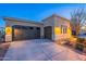 Exterior view of a three-car garage with modern doors and well-lit driveway at 1275 E Verde Blvd, Queen Creek, AZ 85140