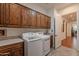 Well-equipped laundry room with front-load washer/dryer, wood cabinets, tile floor and countertops at 1275 E Verde Blvd, Queen Creek, AZ 85140