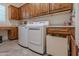 Spacious laundry room featuring cabinets, countertop, stainless steel washer/dryer, and tile flooring at 1275 E Verde Blvd, Queen Creek, AZ 85140