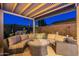 Relaxing covered patio with a large sectional sofa and a stylish round fire pit table at 1275 E Verde Blvd, Queen Creek, AZ 85140