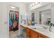 Bathroom featuring vanity and walk-in closet, offering storage solutions and a tidy space at 13026 W Peach Blossom Dr, Sun City West, AZ 85375