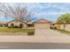 Inviting single-story home with a desert landscape, long driveway and an attached two-car garage at 13026 W Peach Blossom Dr, Sun City West, AZ 85375