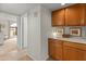 Hallway with built-in cabinets and drawers, plus an archway to a well-lit bedroom, offering ample storage and elegant design at 13026 W Peach Blossom Dr, Sun City West, AZ 85375