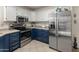 Modern kitchen with stainless steel appliances, navy and white cabinets, and ample counter space at 13026 W Peach Blossom Dr, Sun City West, AZ 85375