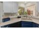 Bright kitchen featuring a double sink, navy lower cabinets and ample natural light at 13026 W Peach Blossom Dr, Sun City West, AZ 85375