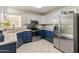 Well-lit kitchen features stainless steel appliances, modern two-tone cabinetry, and neutral countertops at 13026 W Peach Blossom Dr, Sun City West, AZ 85375