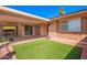 Outdoor patio area with sliding glass doors, artificial turf, and brick accents at 13621 N Emberwood Dr, Sun City, AZ 85351