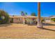 Spacious backyard featuring a covered patio, desert landscaping and mature palm tree at 13621 N Emberwood Dr, Sun City, AZ 85351