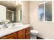 Bathroom features wood cabinets, a vanity sink, and a toilet with a shower with tile surround at 13621 N Emberwood Dr, Sun City, AZ 85351