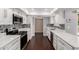 Kitchen featuring stainless steel appliances, white cabinets and mosaic backsplash at 13621 N Emberwood Dr, Sun City, AZ 85351