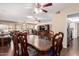 Spacious living room featuring a wooden dining table and ceiling fan at 13621 N Emberwood Dr, Sun City, AZ 85351