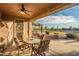 Covered patio with a ceiling fan and outdoor seating area overlooking the golf course at 15131 W Daybreak Dr, Surprise, AZ 85374