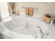 Close-up of a pristine white bathtub with modern fixtures and elegant neutral decor at 15131 W Daybreak Dr, Surprise, AZ 85374