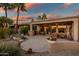 Covered patio has outdoor kitchen, dining area, and relaxing water feature with lush landscaping at 15131 W Daybreak Dr, Surprise, AZ 85374