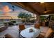 Relaxing outdoor patio area with a table, chairs, built-in grill and a stunning desert golf course view at 15131 W Daybreak Dr, Surprise, AZ 85374