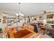 Open-concept dining area with a chandelier, wood table, and views into the living room and kitchen at 15131 W Daybreak Dr, Surprise, AZ 85374