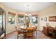 Bright dining area with large windows, wood table, and traditional chandelier, offering a cozy space for meals at 15131 W Daybreak Dr, Surprise, AZ 85374