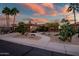 Beautiful single-story home with a desert landscape featuring mature palm trees, cacti and stone accents at 15131 W Daybreak Dr, Surprise, AZ 85374