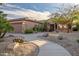 Exterior view of home featuring desert landscaping, stone accents, and a two-car garage at 15131 W Daybreak Dr, Surprise, AZ 85374