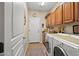 Functional laundry room with washer, dryer, storage cabinets, and a utility sink, designed for convenience at 15131 W Daybreak Dr, Surprise, AZ 85374