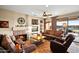 Warm living room featuring a fireplace, comfortable seating, and expansive windows for natural light and views at 15131 W Daybreak Dr, Surprise, AZ 85374