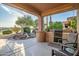 Covered patio boasts a built-in outdoor kitchen and tranquil water feature at 15131 W Daybreak Dr, Surprise, AZ 85374