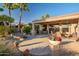 Back patio featuring outdoor kitchen, covered seating area, and landscaped yard at 15131 W Daybreak Dr, Surprise, AZ 85374